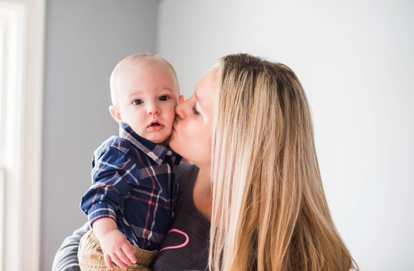 Mamá dando un beso a su bebé al regresar de la licencia de maternidad